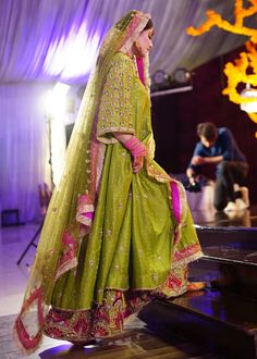 a woman in a green lehenga and pink dupatta