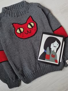 a sweater with an image of a cat on the front and a picture of a woman's face on the back