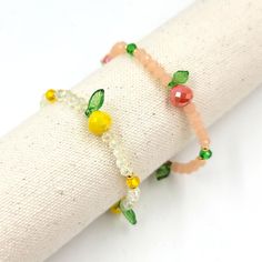 the bracelet is decorated with fruit and beads