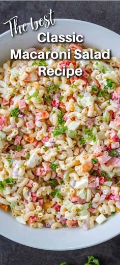 the best macaroni salad recipe in a white bowl with parsley on top