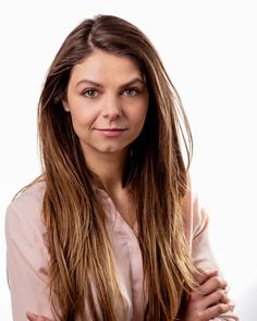 a woman with long hair posing for the camera