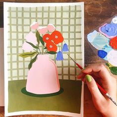 a person is painting flowers in a vase on paper with watercolors and crayons