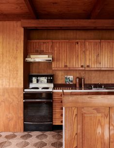 a kitchen with wood paneling and black appliances