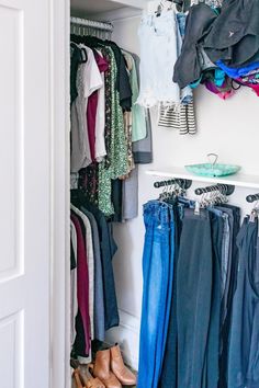 an open closet with clothes and shoes hanging on the wall, next to a white door