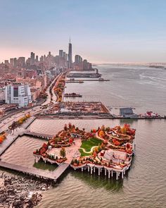 an aerial view of a city and the ocean with lots of buildings in the background