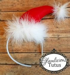 a red and white headband with fluffy white feathers on it, sitting on a wooden surface