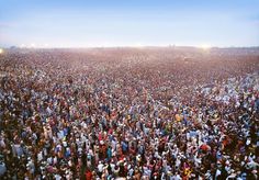 a large group of people standing in the middle of a field