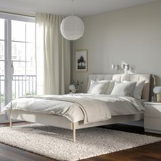 a bedroom with a white bed and wooden floors