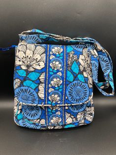 "Perfect purse for your winter vacation to warmer climate! Charming Blue Bayou crossbody shoulder bag in a signature Vera Bradley fabric!  True classic Vera Bradley with insignia on the hardware and fabric and zipper pulls.  Blue, white, black florals with same colours in zigzag lining.  Age related wear but no rips, tears, stains or damage.   Measures:  12\" high, 11.5\" wide, 38\" long when adjustable fabric strap is extended full length.  Please examine photos carefully for condition; any damage or age related wear is always detailed in the description." School Bag With Cell Phone Pocket In Blue, Blue Rectangular Satchel With Cell Phone Pocket, Blue Shoulder Bag For Travel, Blue School Shoulder Bag With Adjustable Strap, Blue School Bag With Cell Phone Pocket, Blue Satchel Shoulder Bag For Travel, Blue Shoulder Bag Satchel For Travel, Blue Shoulder Satchel For Travel, Blue Travel Backpack Shoulder Bag