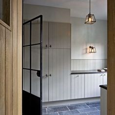 an open door leading to a kitchen with white cabinets