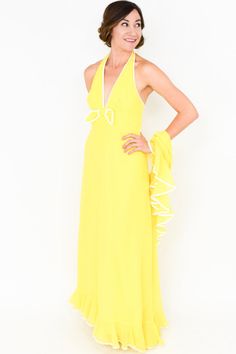 "~1970s bright canary yellow cotton halter maxi dress ~ White piping at the collar, bow, and ruffle hem ~ Low, open back ~ Zipper up the back ~ Fully lined ~ Matching shawl with ruffle ~ Excellent Label: Miss Elliotte Bust- 32\" (81.5 cm) Waist- 26\" (66 cm) Hips- 38\" (96.5 cm) Length- 56\" (142 cm) More Incredible Vintage: glennasvintageshop.etsy.com Vintage Jewelry: glennasjewels.etsy.com Instagram @glennas_clothing Facebook https://www.facebook.com/glennasclothing Model Info: Size 2, Height Yellow Halter Neck Maxi Dress For Evening, Flowy Yellow Halter Neck Dress, Yellow Fitted Halter Neck Maxi Dress, Yellow Halter Dress, Yellow 70s Dress, Vintage Yellow Dangle Jewelry, Yellow V-neck Chiffon Maxi Dress, 1970s Style Yellow Spring Dress, Dress Miss