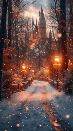 a snow covered path leading to a castle in the distance with lights shining on it