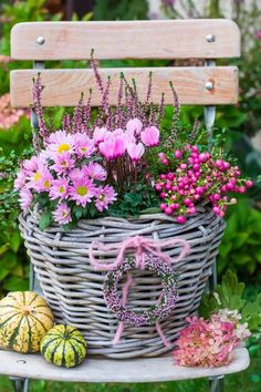 a basket filled with flowers sitting on top of a bench