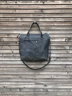 Black canvas leather tote bag made for daily use to take with you everywhere, also the office, smart enough for any occasion The bag is constructed out of heavy weight waxed canvas in black with a bottom in leather, closing with a zipper. There is an outside pocket with rounded edges closing with a snap on one side Handles and cross body strap are made in vegetable tanned leather. Inside the bag is lined with cotton canvas with a padded laptop compartment and on the other side a double slip pock Waxed Canvas Satchel Briefcase For Everyday, Everyday Satchel With Waxed Finish And Double Handle, Leather Canvas Bag With Zipper Pocket For Everyday, Waxed Canvas Satchel Weekender Bag For Everyday, Everyday Leather Canvas Bag With Zipper Pocket, Waxed Finish Satchel Weekender Bag For Everyday Use, Waxed Canvas Briefcase For Everyday Use, Urban Leather Shoulder Bag For Everyday Use, Everyday Waxed Finish Satchel Weekender Bag