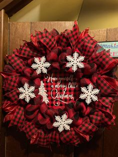 a red and black wreath with white snowflakes