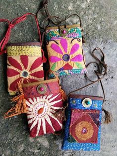 four small purses sitting on top of a stone floor next to each other with eyeballs in them