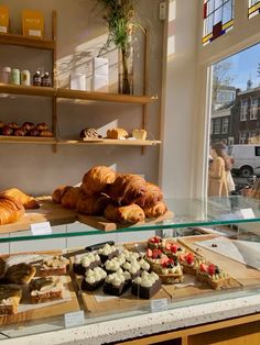 the bakery has many different types of pastries on display in front of the window