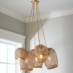 a chandelier hanging from the ceiling in a room with white walls and windows