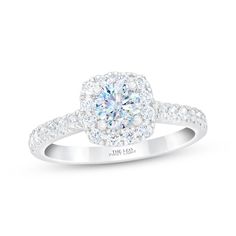 a white gold engagement ring with diamonds on the band and an oval halo setting in the center