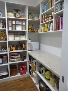 an organized pantry with white shelving and lots of food