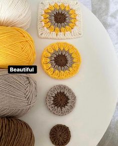 four balls of yarn sitting on top of a white plate with the words beautiful written across it