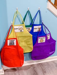 three bags hanging on the wall with name tags