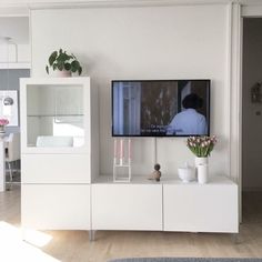 a flat screen tv sitting on top of a white entertainment center