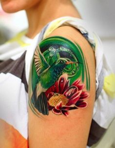 a woman's arm with a bird and flower tattoo on it