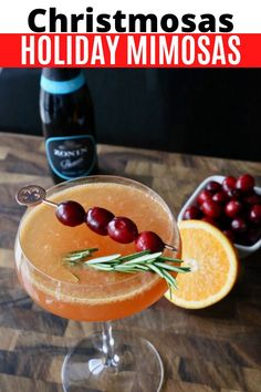 a holiday mimosa is garnished with cranberries and rosemary