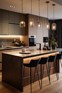 a modern kitchen with wooden flooring and pendant lights hanging from the ceiling over the island