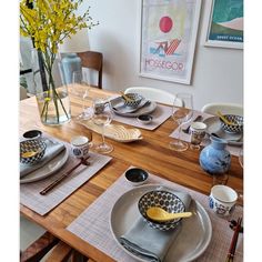 a wooden table topped with plates and bowls