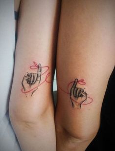 two people with tattoos on their arms holding hands