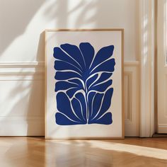 a blue and white art print sitting on top of a hard wood floor next to a door