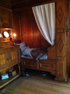 a bedroom with wood paneling and white curtains