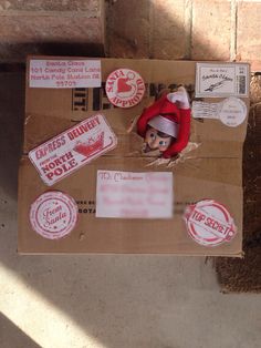 a cardboard box with some stickers on it and a small elf's hat