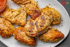 grilled chicken wings on a plate with ketchup