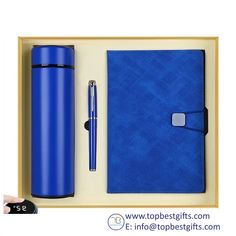 a blue notebook and pen in a wooden box with the lid open next to it