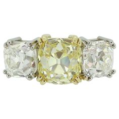 Here we have an exceptional three-stone diamond ring. At the centre of the face we find a breathtaking old mine cut diamond possessing a natural vivid fancy yellow colour tone weighing an impressive 3.02 carats which sits in a rich yellow gold double four-clawed setting. This proud principal stone is accentuated and flanked on either side by a single chunky bright white matching stone of distinguishable stature. The piece is made complete by a plain polished band for a subtle yet elegant finish. Condition: Used (Very Good) Weight: 7.0 grams Ring Size: L (53) Face Dimensions: 20mm x 8mm Yellow Diamond Weight: 3.02ct Further Diamonds Total: 3.01ct (1.51ct & 1.50ct) Diamond Details: Colour: D&E, Clarity: VVS2&VS1 Grading Laboratory: GIA Tested As: 18ct Gold Box: The Vintage Jeweller Ring Face Dimensions, Three Stone Diamond Ring, Old Mine Cut Diamond, Yellow Gold Diamond Ring, Vintage Style Rings, Three Stone Diamond, Yellow Colour, Three Stone Rings, Stone Cuts