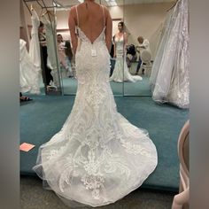 a woman is looking at her wedding dress in the mirror