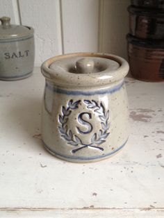 a white and blue ceramic container sitting on top of a counter next to other containers