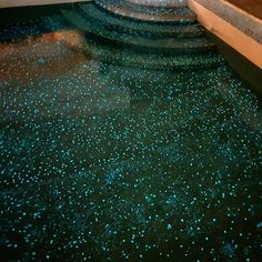 the floor is covered with blue stars in an indoor swimming pool that's surrounded by concrete steps