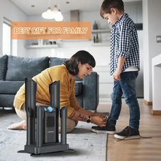 a woman kneeling down next to a child on the floor with two electronic devices in front of her