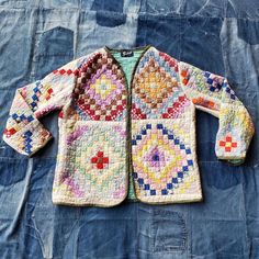 an old sweater is laying on a blue cloth covered in fabric and crochet