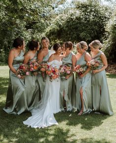 a group of women standing next to each other on top of a lush green field