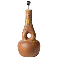 a wooden vase with a small metal object in the middle of it's body