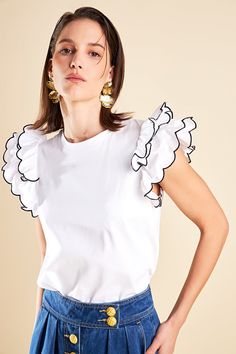 Elevate your wardrobe with our Merrow Stitch Ruffle Top. The rounded neckline adds a touch of femininity while the ruffle shoulder detail adds a playful and trendy touch. The contrast ruffle hem merrow stitch creates a unique and eye-catching look. With a regular length this top is perfect for both casual and dressy occasions. Made with high-quality materials this top is not only fashionable but also comfortable to wear. Perfect for standing out from the crowd our Merrow Stitch Ruffle Top is a m White Trendy Tops With Ruffled Straps, White Trendy Top With Ruffled Straps, White Tops With Ruffles And Ruffled Straps, White Tops With Ruffled Straps, White Top With Ruffled Hem And Straps, White Tops With Ruffled Straps And Details, Chic Crew Neck Tops With Ruffle Hem, Trendy White Ruffled Top, Chic White Ruffled Top