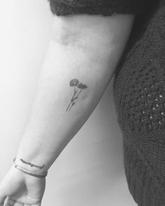 a small flower tattoo on the arm