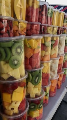 many plastic containers filled with different types of fruit