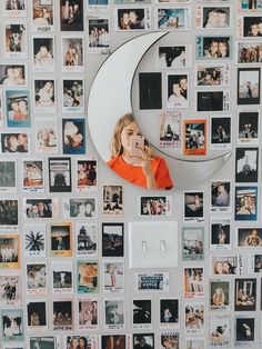 a child is looking up at the moon in front of a wall covered with photos