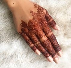 a woman's hand with henna tattoos on it